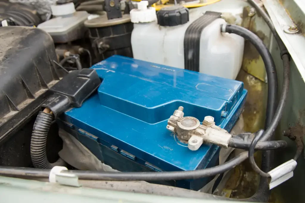 Blue deep cycle dump trailer battery installed with cables in compartment