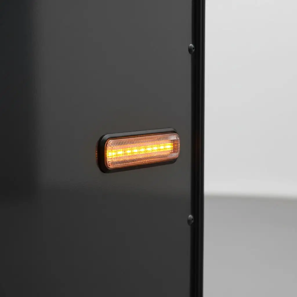 Close-up of a bright, amber trailer LED marker light on a trailer.